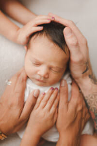 newborn photo including family's hands